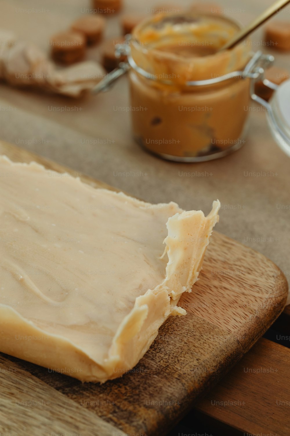 a piece of cheese sitting on top of a wooden cutting board