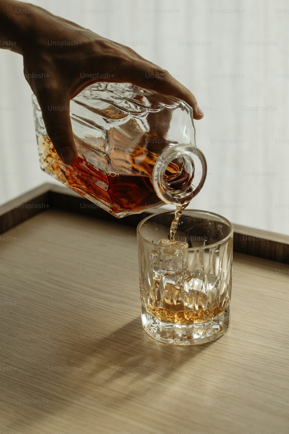 uma pessoa derramando uma bebida em um copo