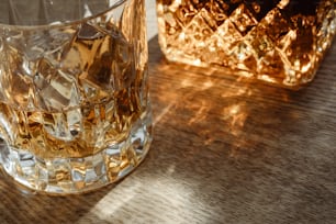Ein Glas Whisky sitzt auf einem Tisch neben einem anderen Glas
