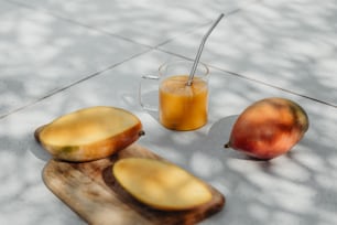 2枚の果物の隣にオレンジジュースのグラス