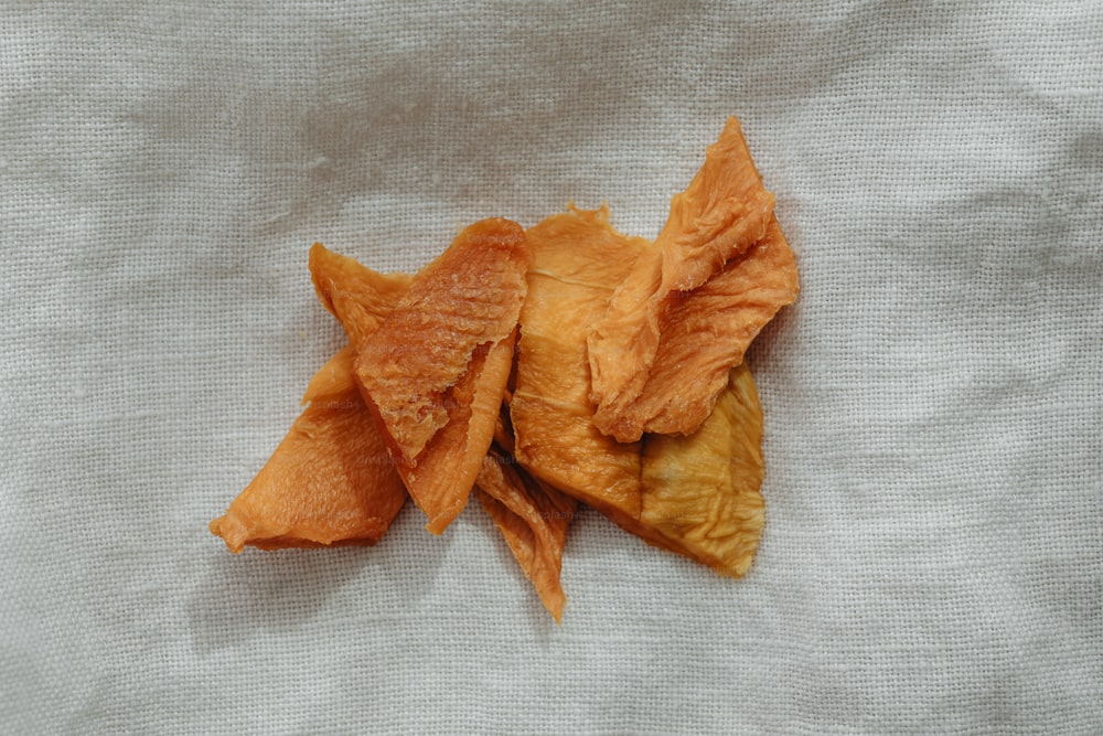 a pile of potato chips sitting on top of a white cloth