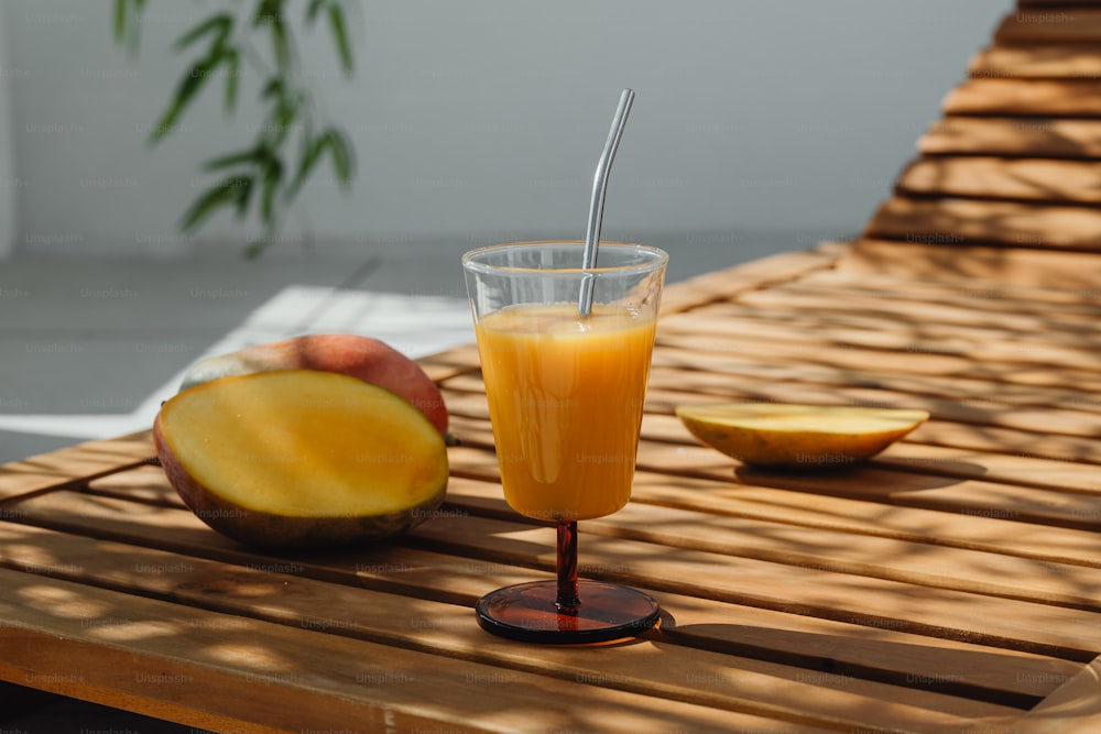 un verre de jus d’orange assis sur une table en bois