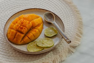 a white plate topped with sliced up mangoes and limes