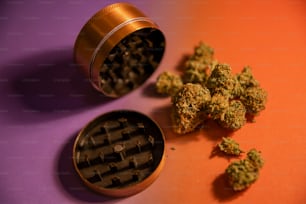 un molinillo y unos cogollos de marihuana sobre una mesa