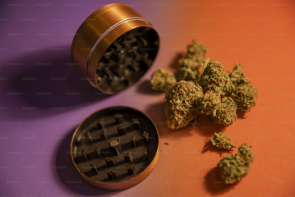 a grinder and some marijuana buds on a table