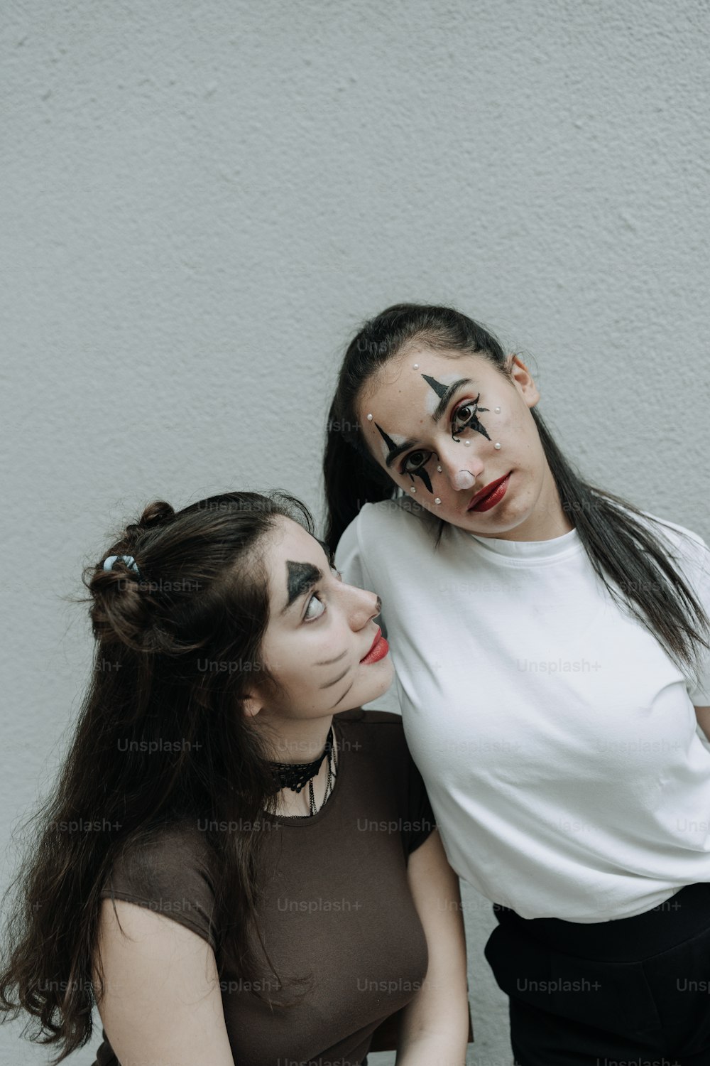 Dos mujeres con maquillaje en la cara posando para una foto