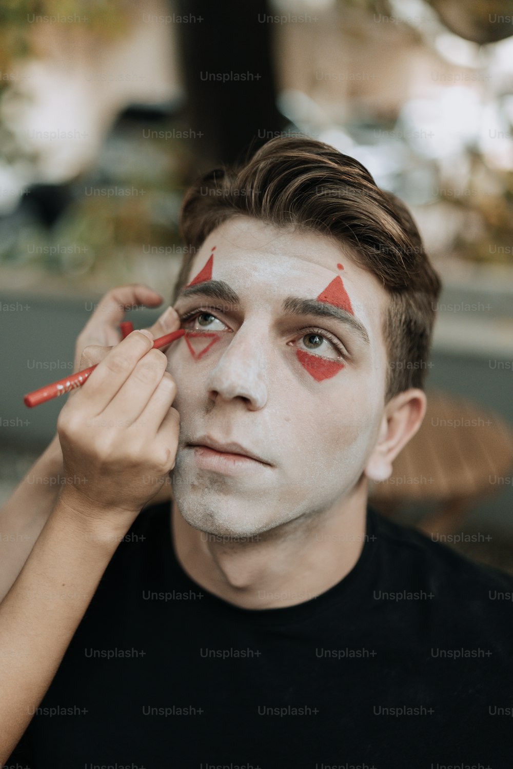 um homem com um triângulo vermelho pintado no rosto