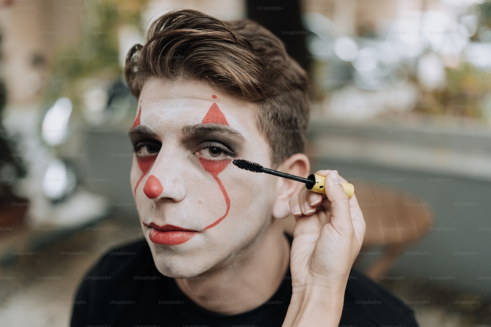 Un uomo con una faccia da clown dipinta sul suo volto