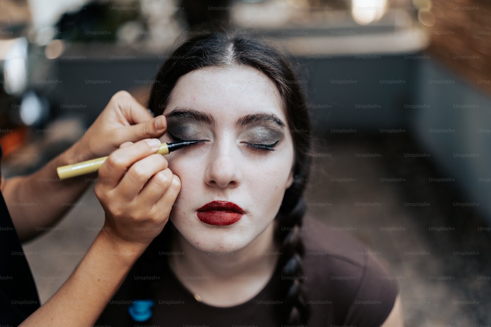 a woman is doing makeup on her face