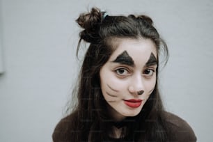 uma mulher com maquiagem de gato preto em seu rosto