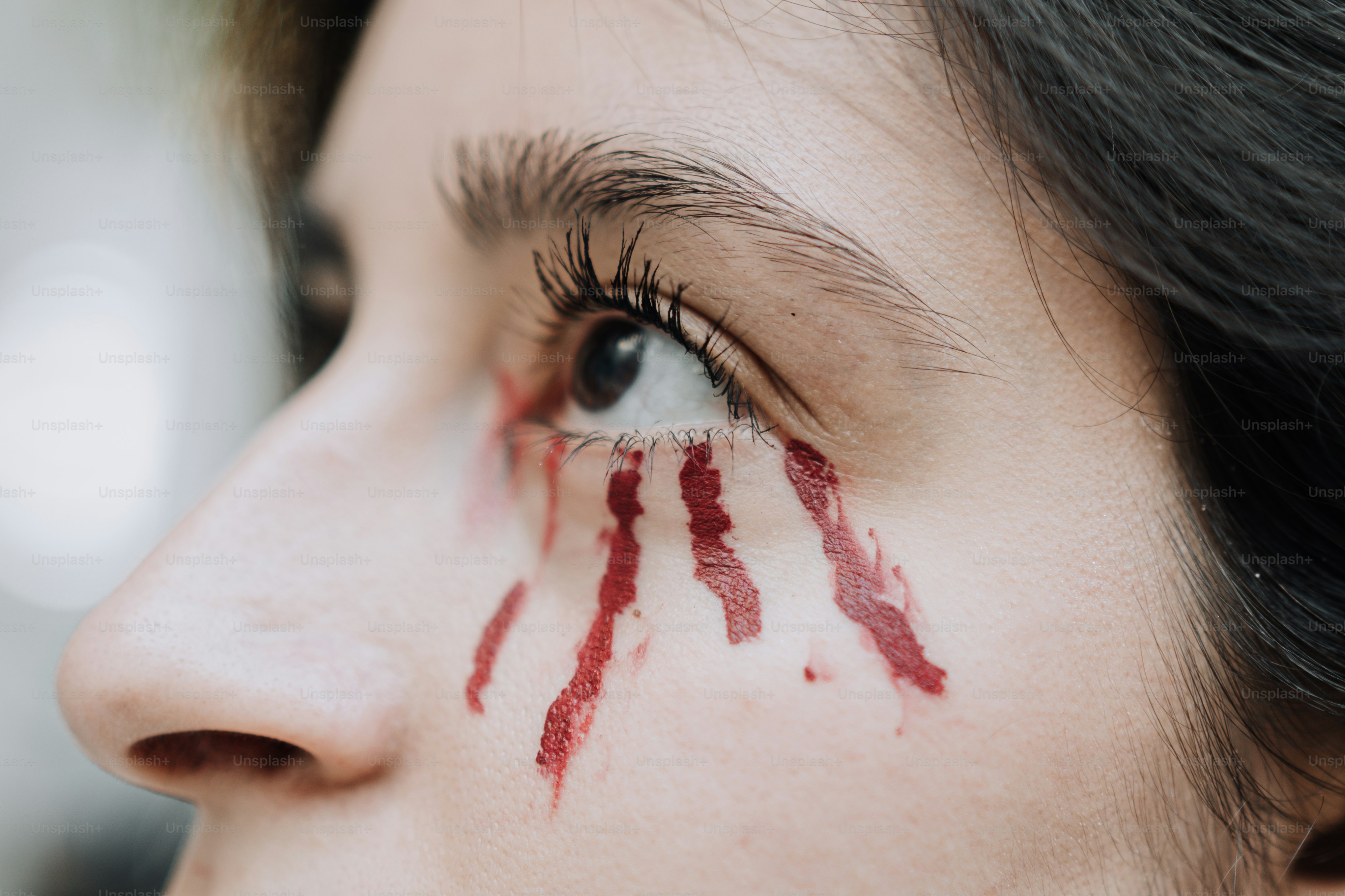 a close up of a woman's face with lipstick painted on her face