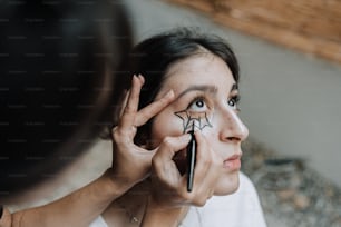 a woman is doing makeup on her face