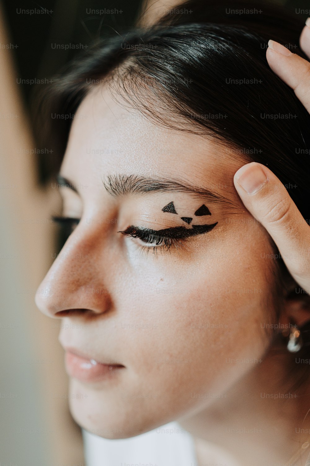 a woman with black eyeliners and a pair of scissors