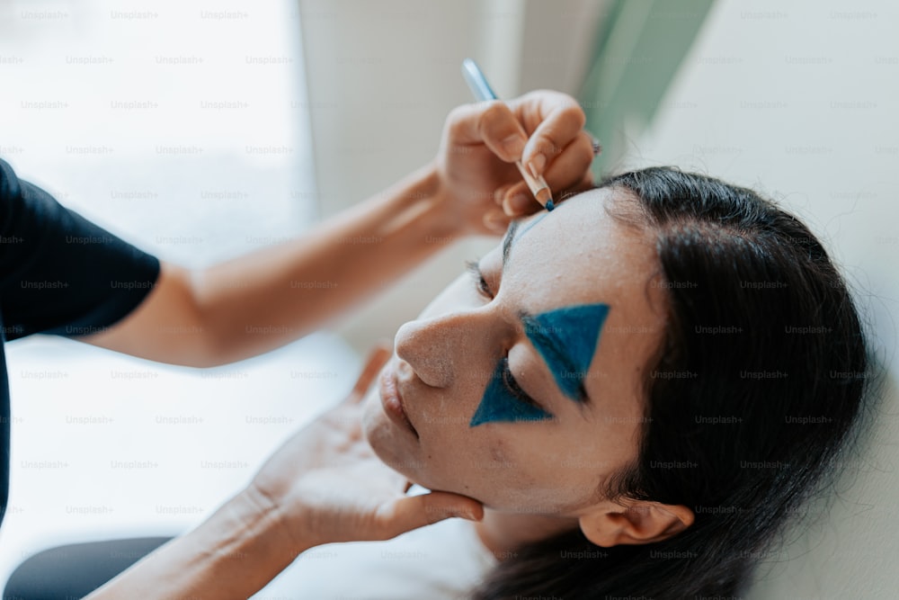 Eine Frau, die sich von einem professionellen Maskenbildner schminken lässt