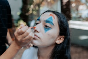 a girl with blue and orange face paint on her face