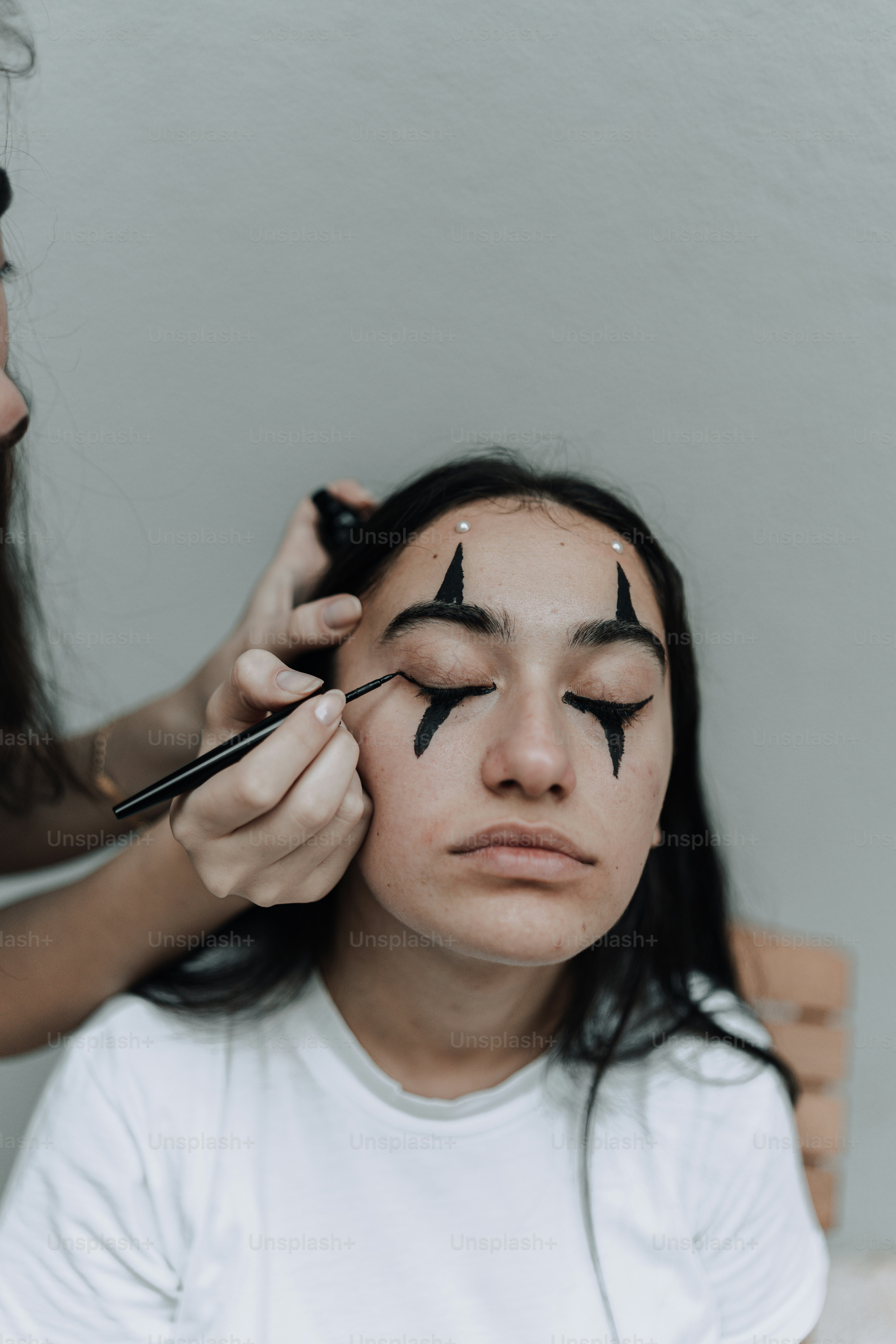 a woman is getting her eyebrows painted