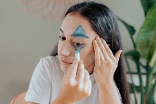 a woman with a blue triangle painted on her face