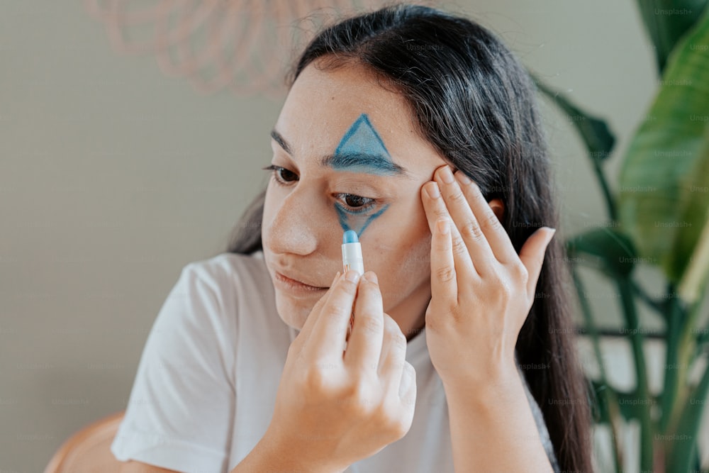 Une femme avec un triangle bleu peint sur son visage