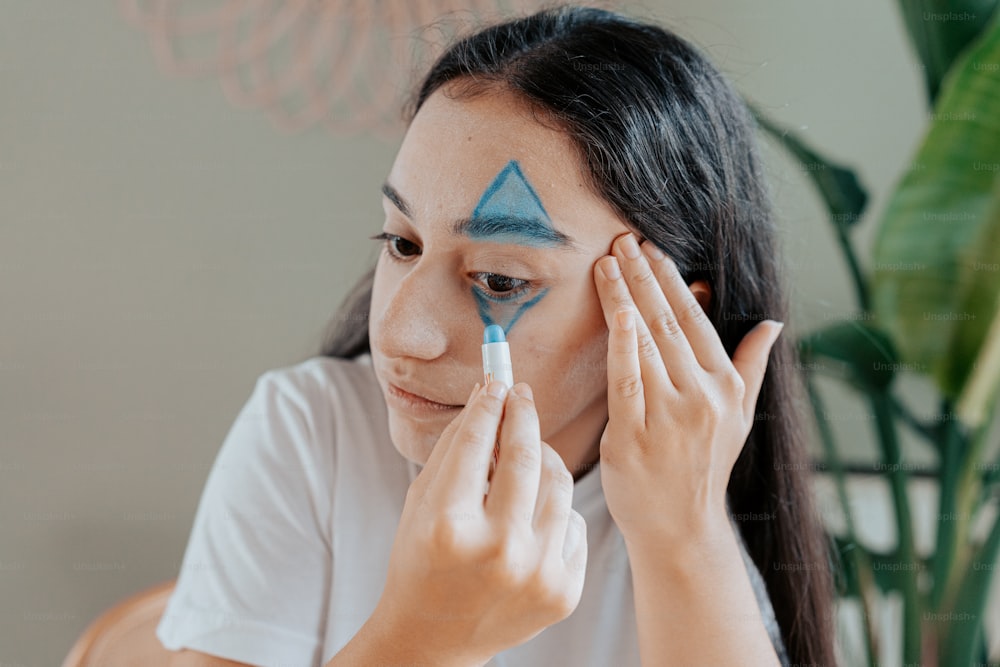 a woman with a blue triangle painted on her face