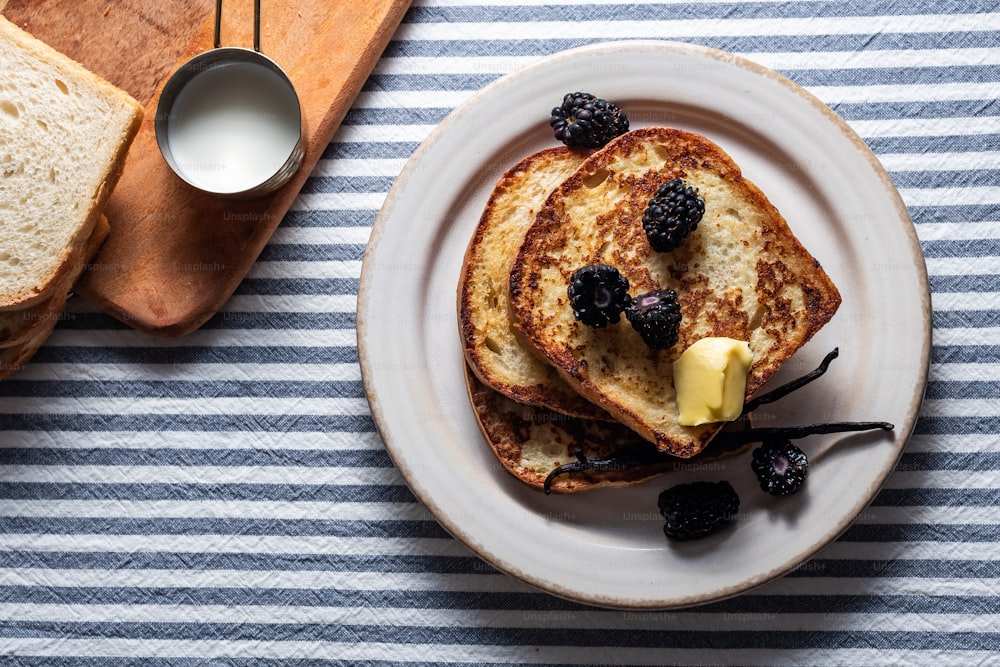 a white plate topped with french toast and berries