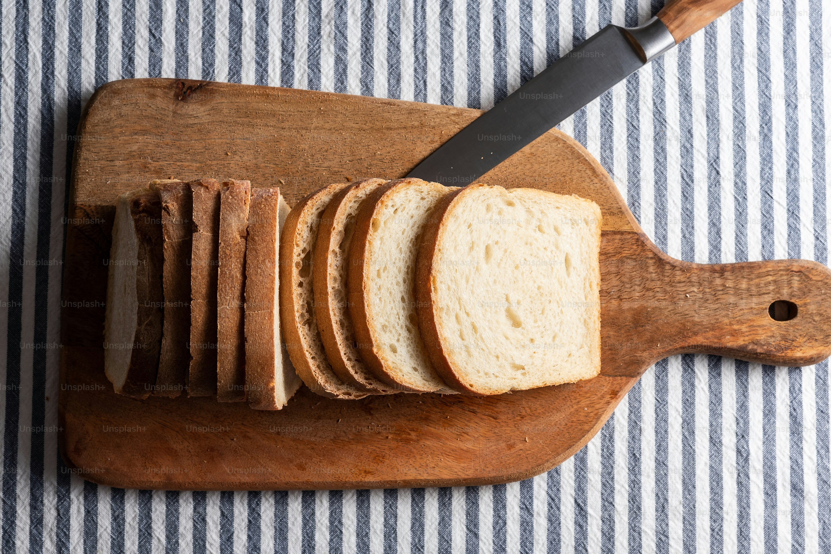 a sliced loaf of bread on a cutting board with a knife