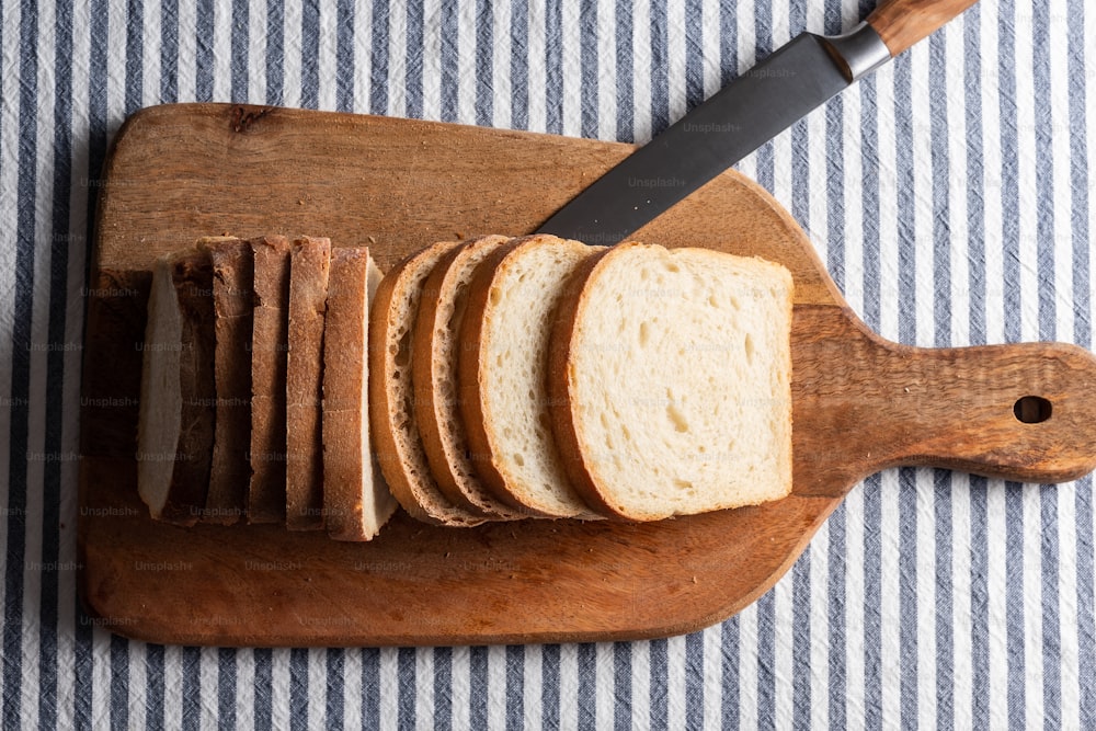 a sliced loaf of bread on a cutting board with a knife