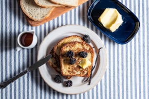 a plate of french toast with butter and berries