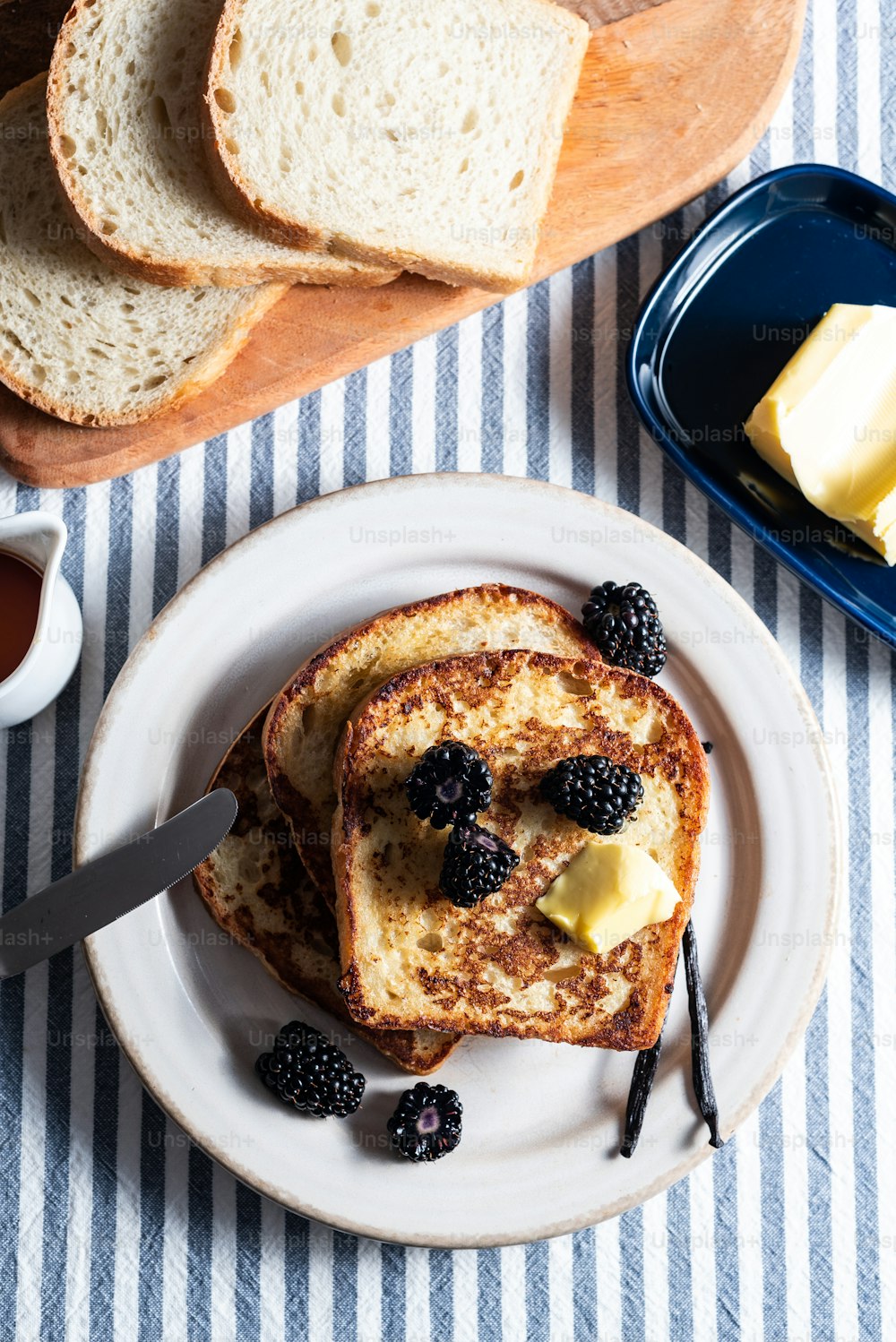 a plate of french toast with butter and berries