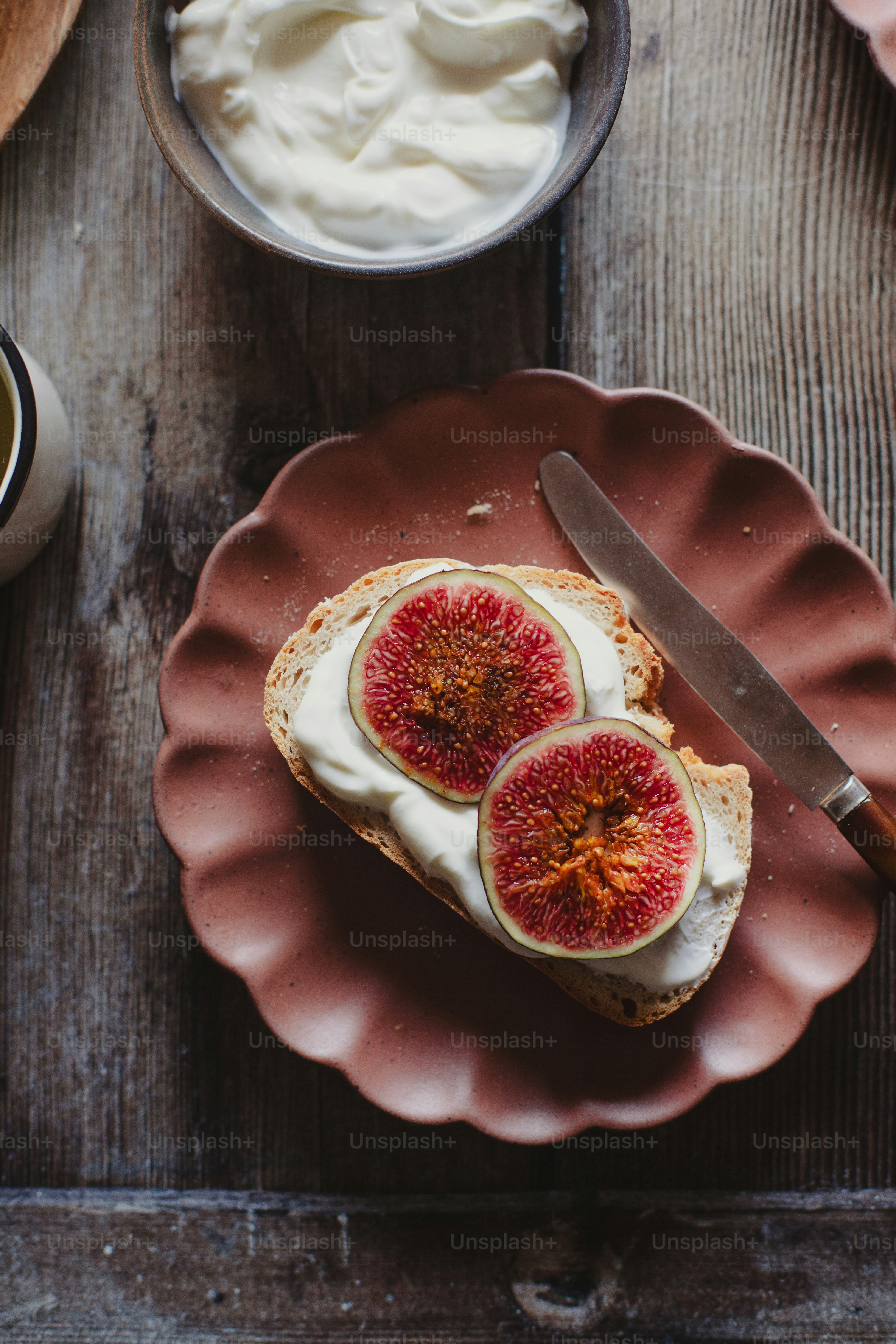 a piece of bread with cream and figs on it
