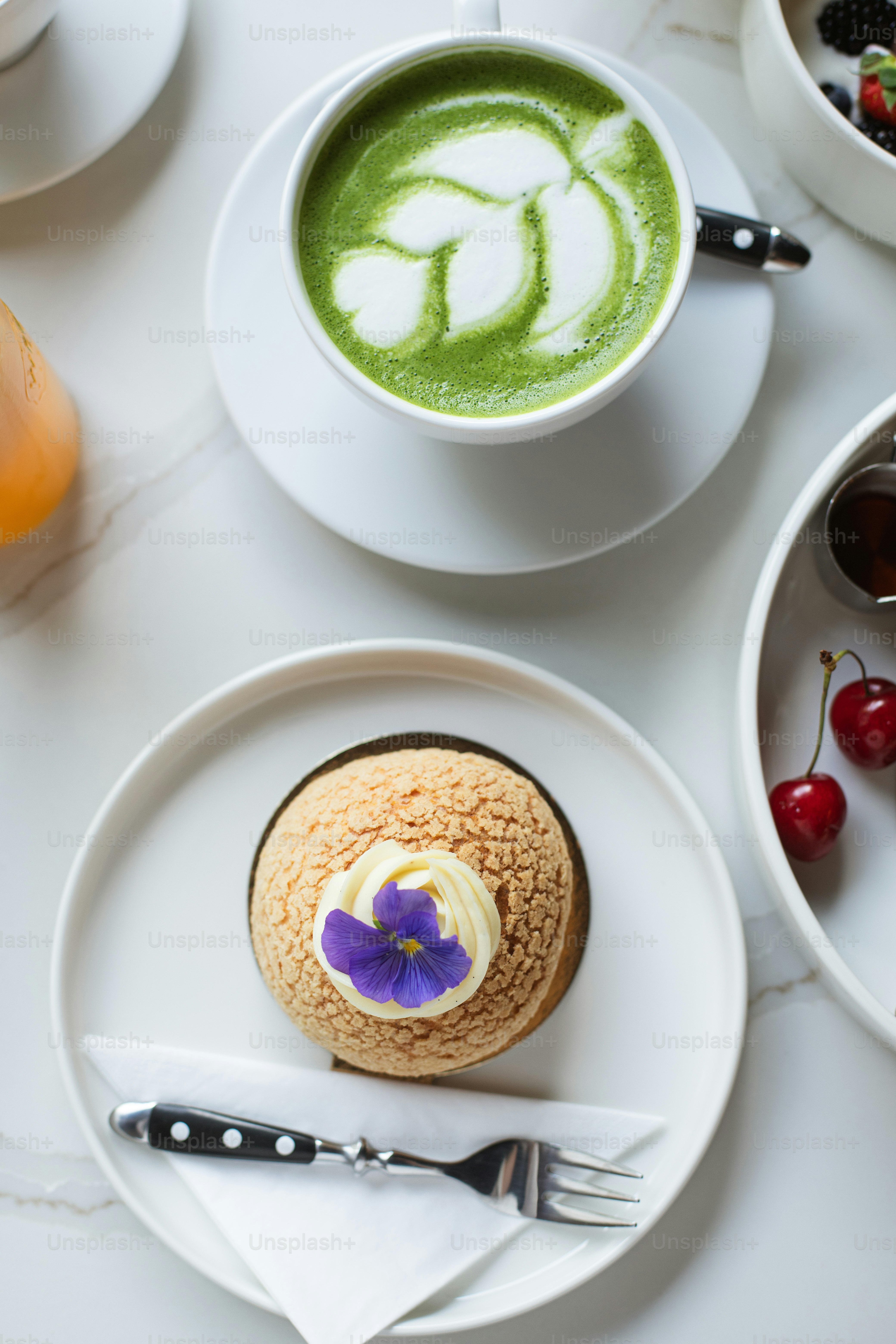 a cup of green tea and a pastry on a plate