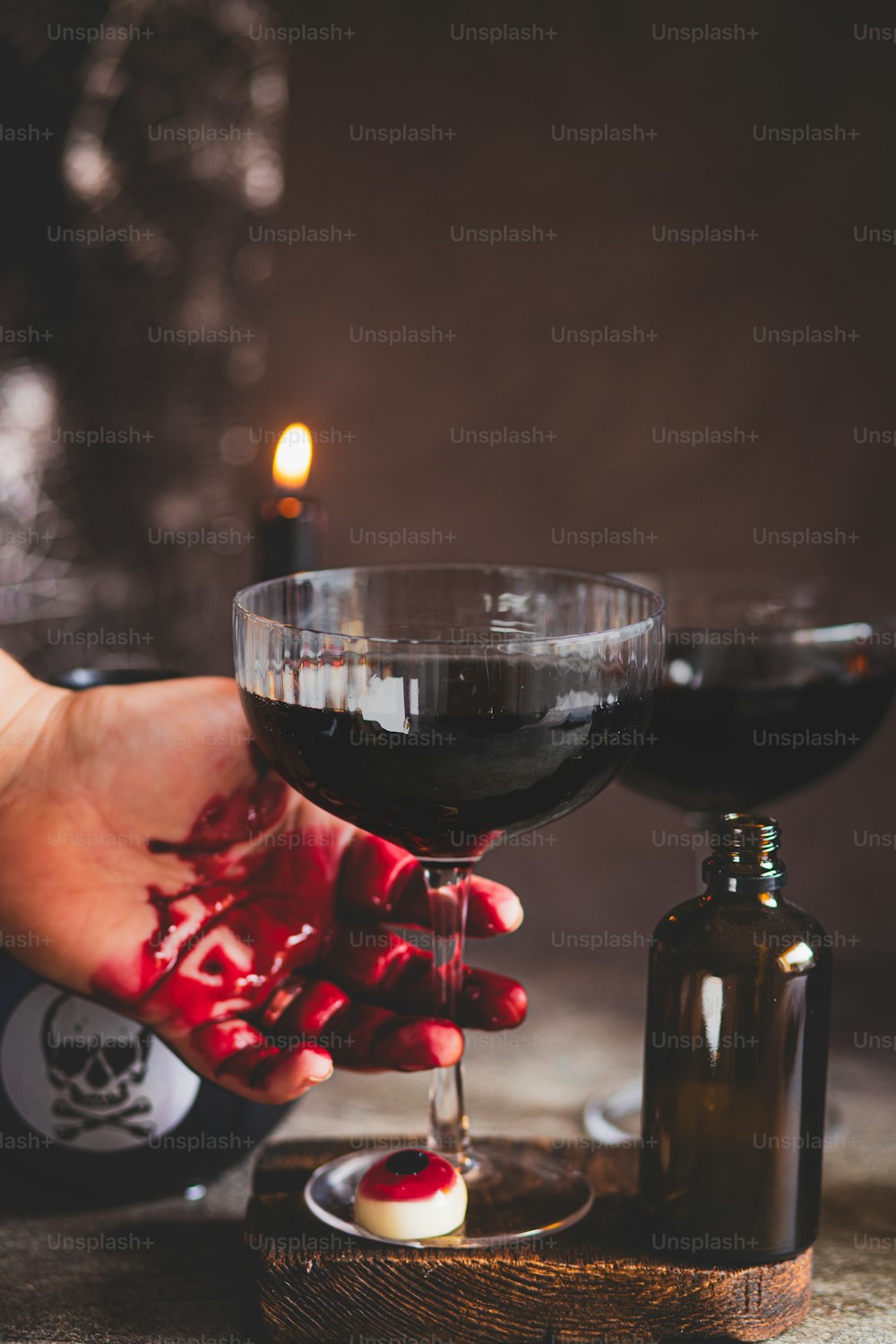 a person holding a glass of wine next to a bottle of wine