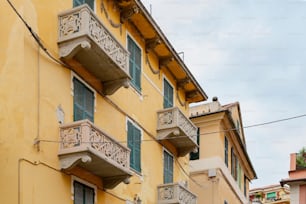 ein gelbes Gebäude mit Balkonen und Balkonen auf den Balkonen