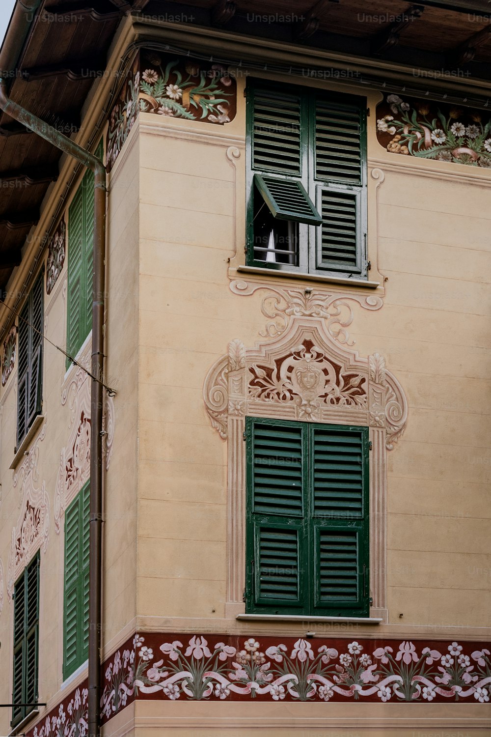 a building with green shutters and a clock