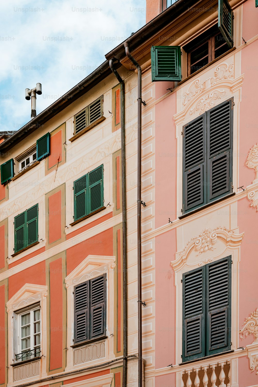 a building with green shutters and a cross on top of it