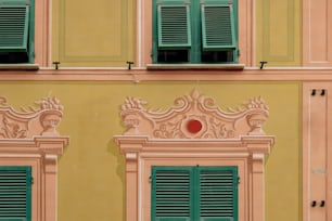 a building with green shutters and a red ball in the window