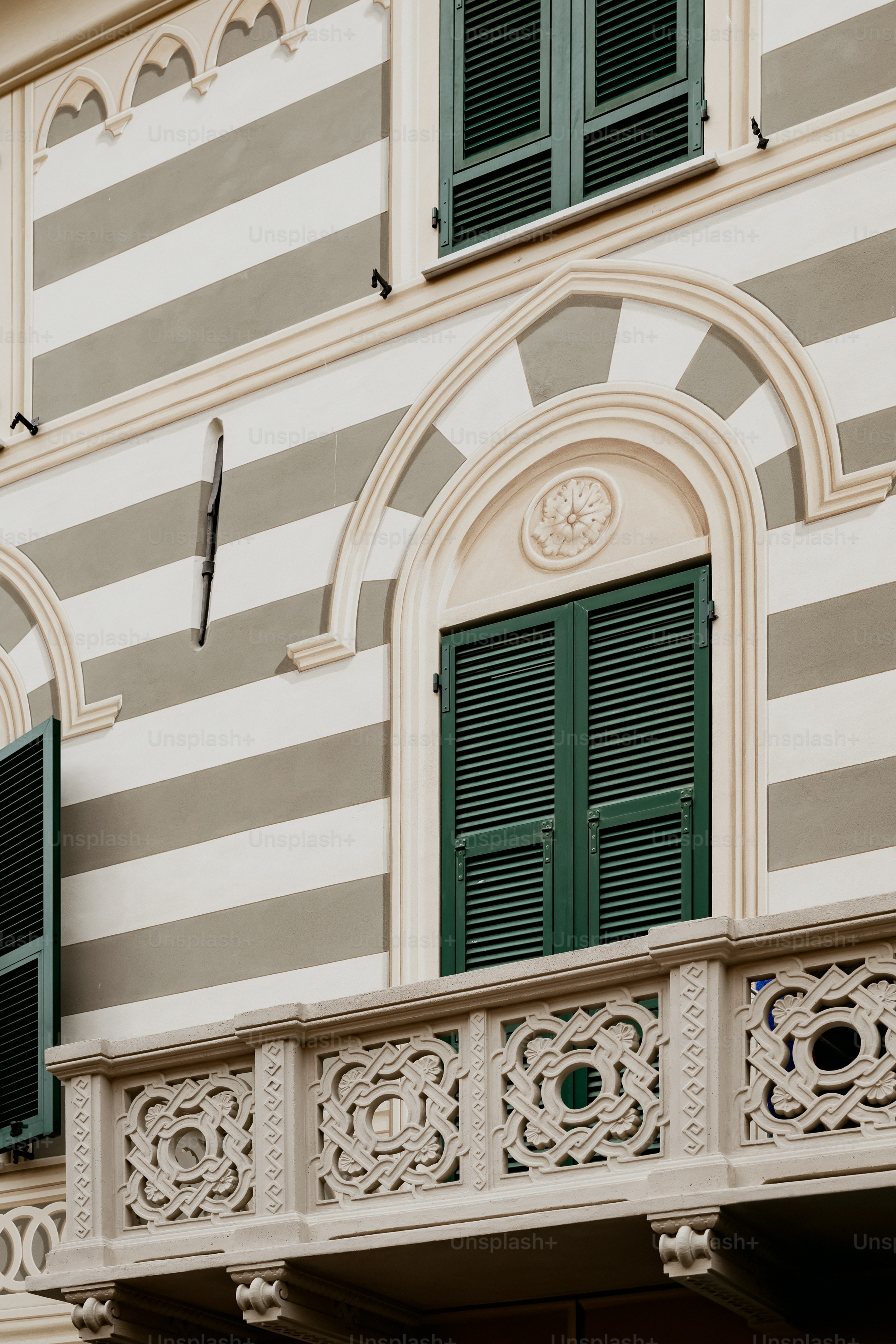 a building with green shutters and a clock