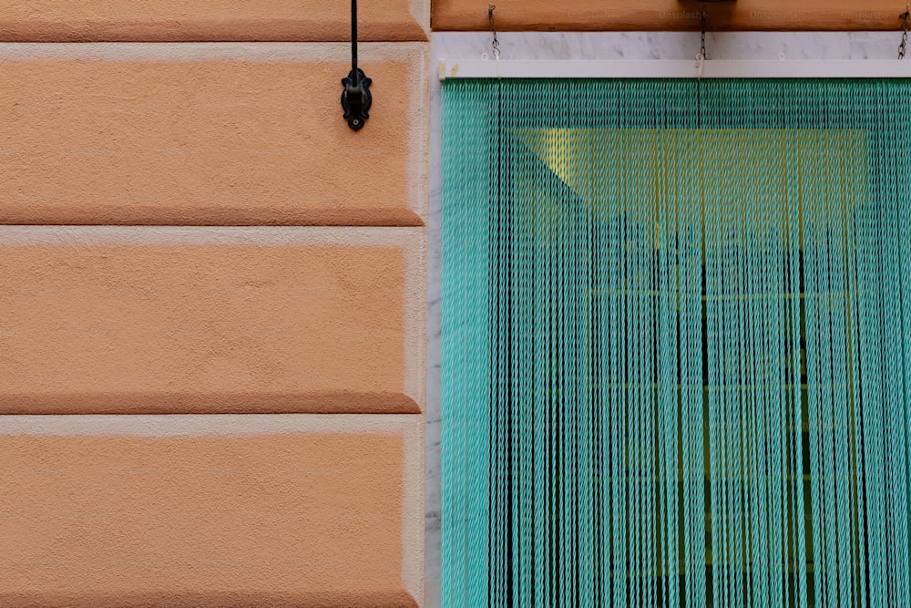 a window with a green curtain hanging from it's side