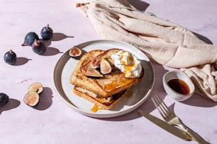 a white plate topped with french toast and sliced figs