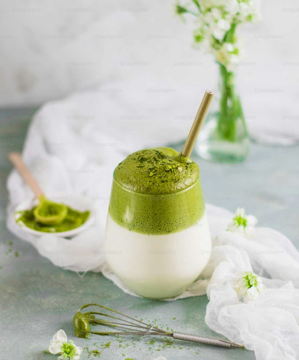 a green and white drink sitting on top of a table