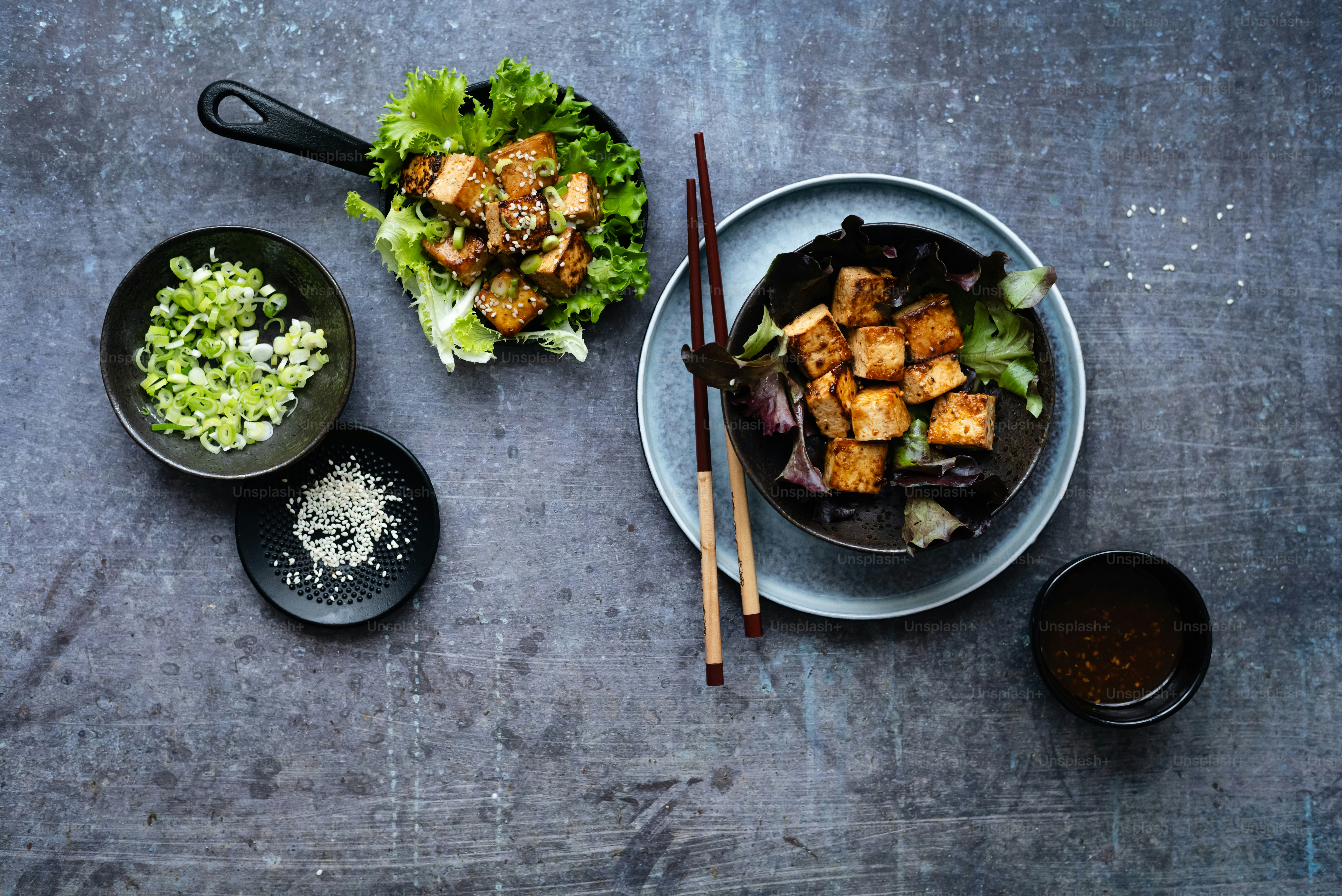 a table topped with plates of food and chopsticks