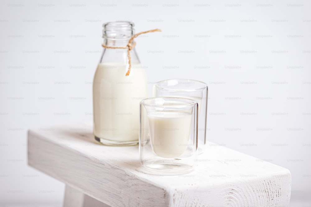 una bottiglia di latte accanto a un bicchiere di latte