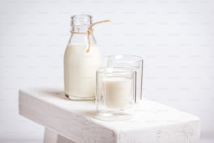 une bouteille de lait à côté d’un verre de lait