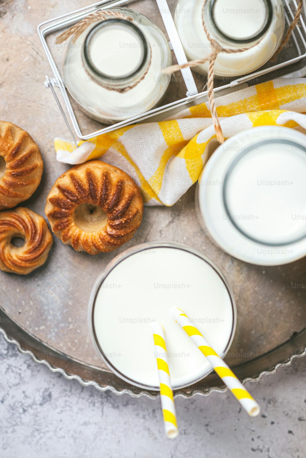 a tray of pastries next to a glass of milk