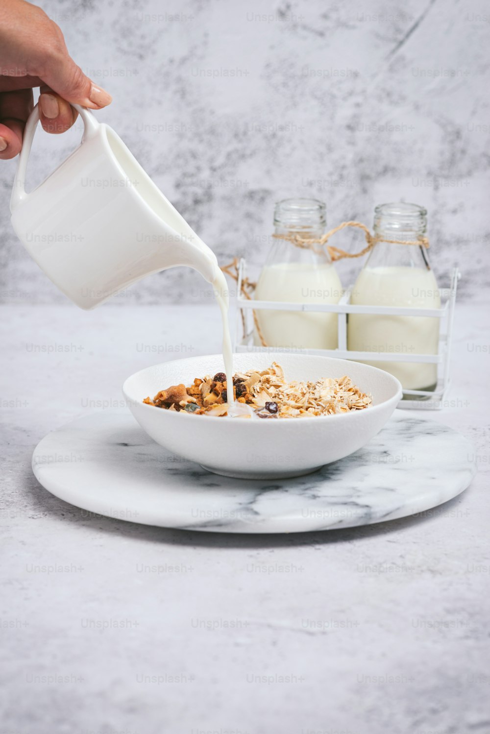 una persona vertiendo leche en un tazón de cereal