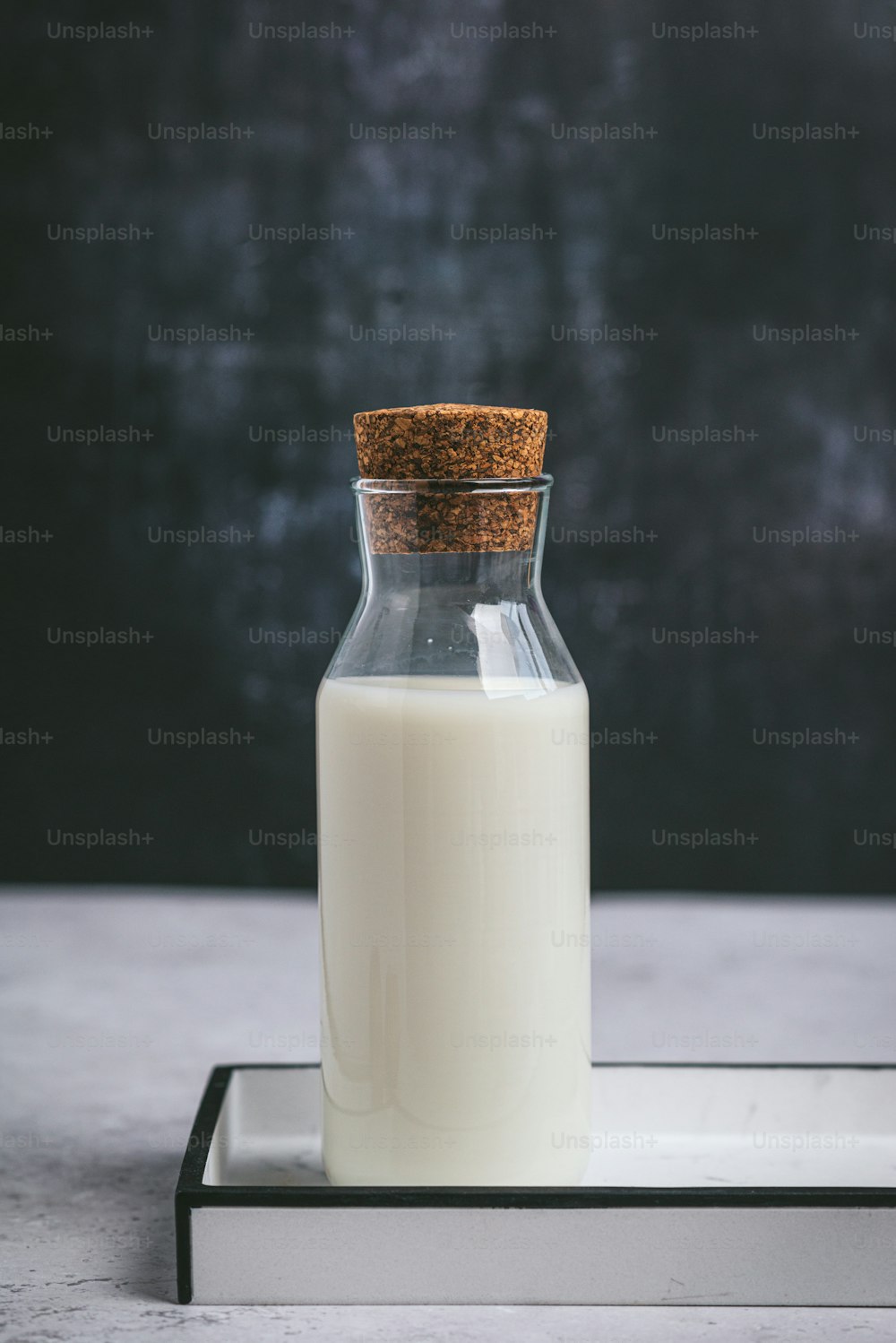 una bottiglia di latte seduta sopra un vassoio di metallo