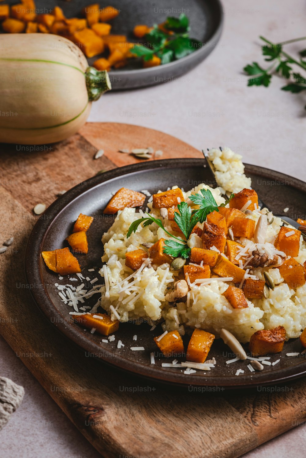 a plate of mashed potatoes and carrots on a cutting board