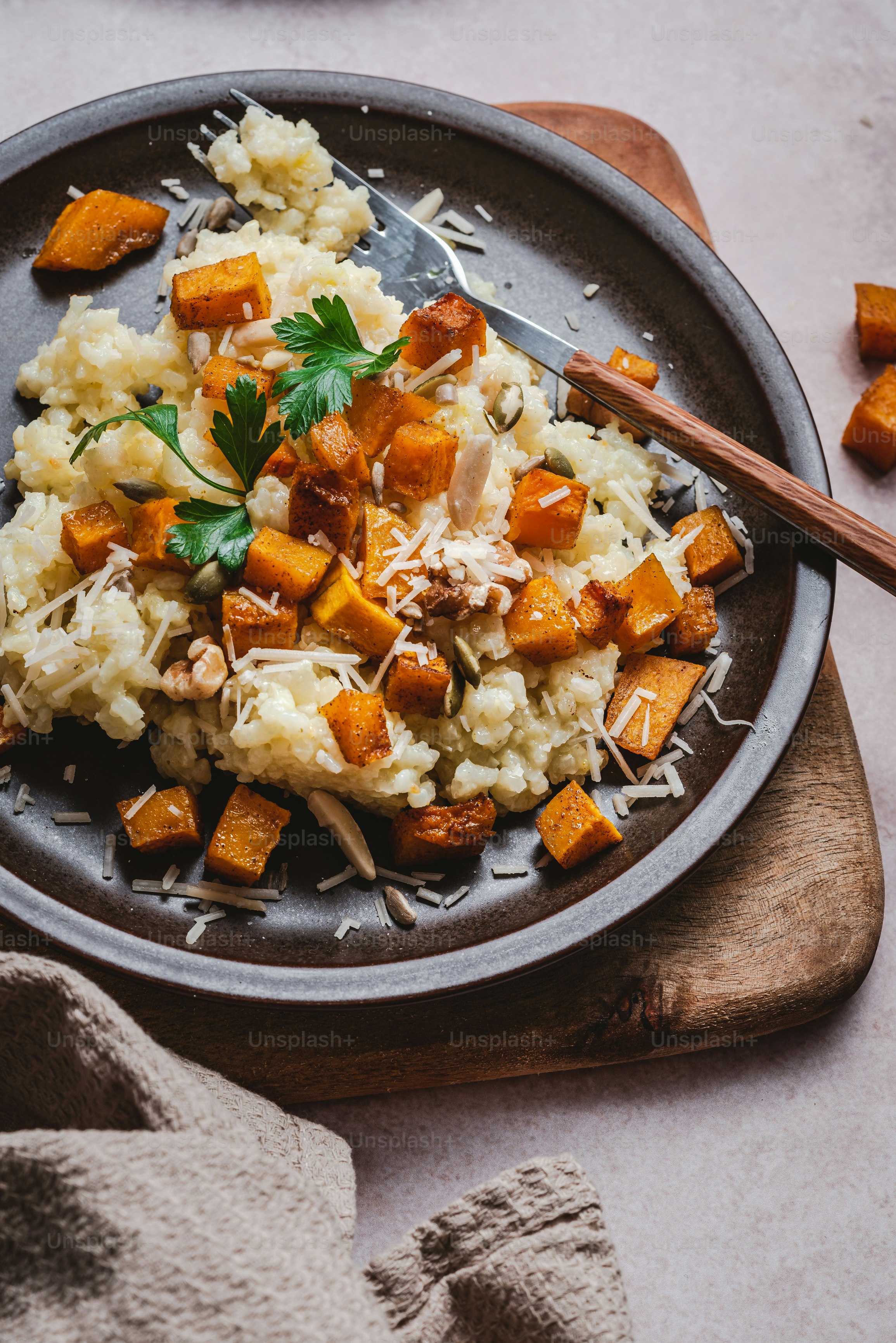 a plate of mashed potatoes with parmesan cheese and parsley