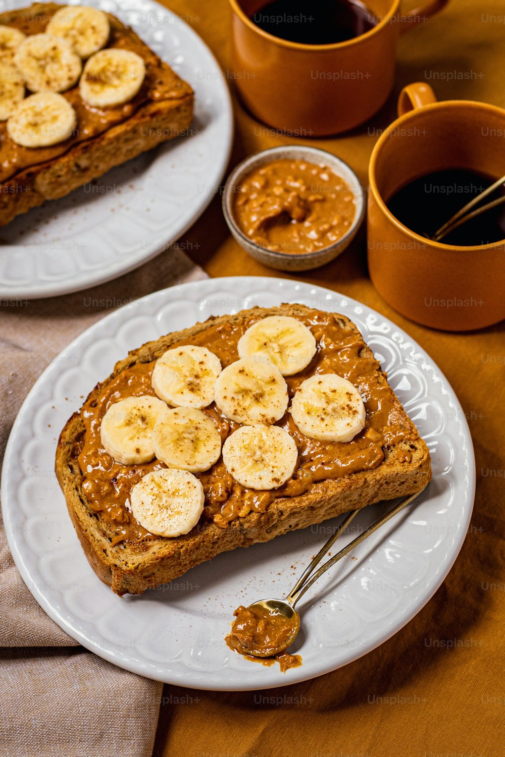 two white plates topped with slices of banana bread