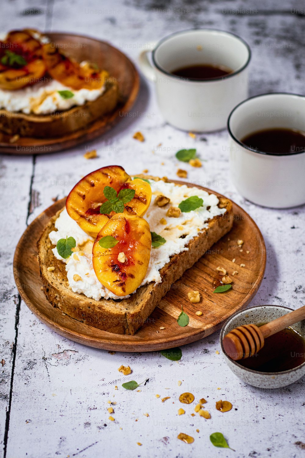 a plate of toast topped with sliced peaches and whipped cream