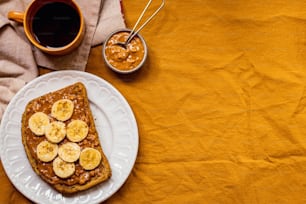 a white plate topped with bananas and peanut butter
